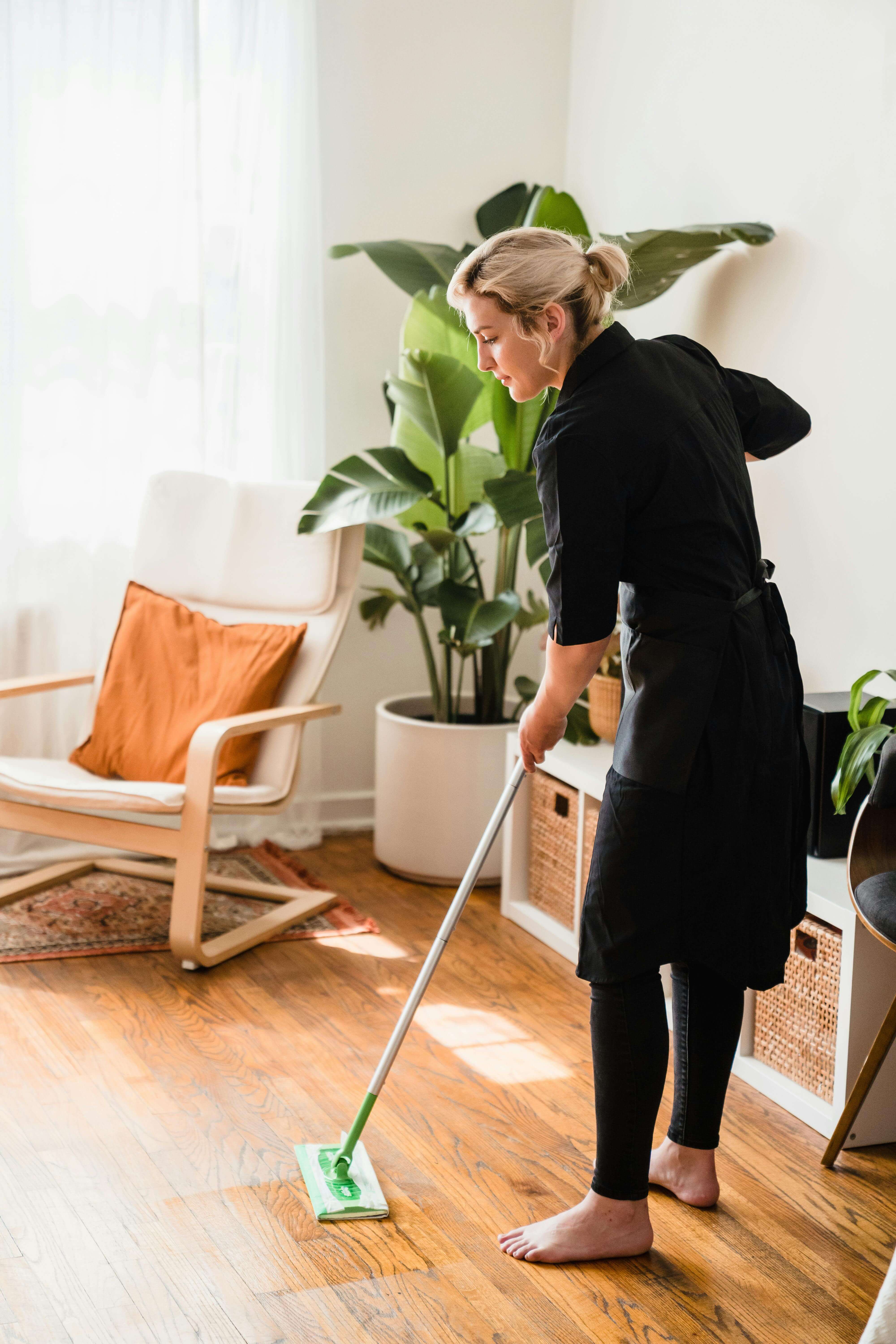 Purely Green cleaner mopping floor in bright living room